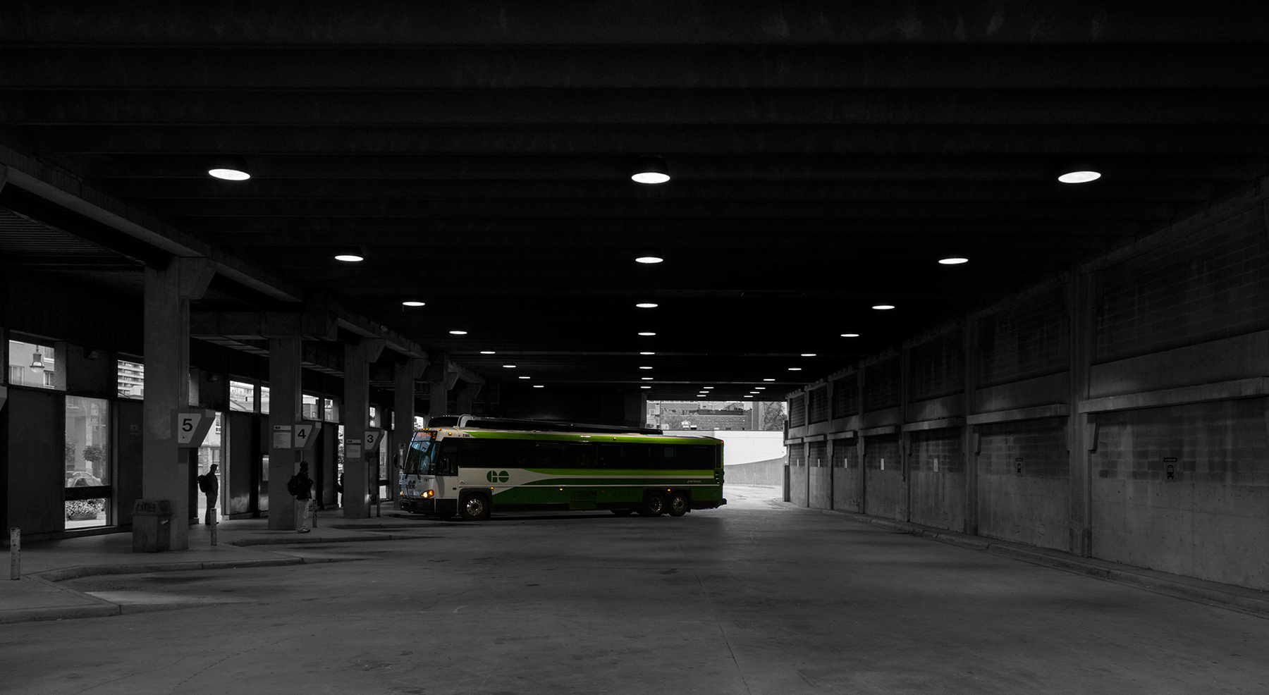 20151128B. A Green GO Bus pulls into Oshawa's grey concrete bus